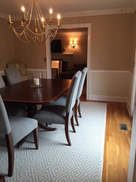 This is an example of a large traditional kitchen/dining room in New York with black walls, carpet and no fireplace.