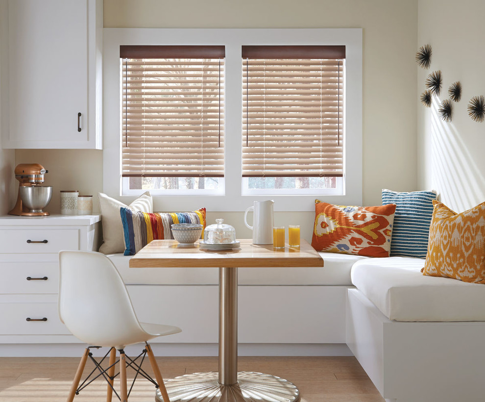 Cette photo montre une salle à manger ouverte sur la cuisine chic de taille moyenne avec parquet clair et un mur beige.