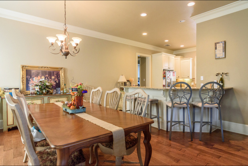 Idée de décoration pour une salle à manger ouverte sur le salon sud-ouest américain de taille moyenne avec un mur beige, un sol en bois brun, aucune cheminée et un sol marron.