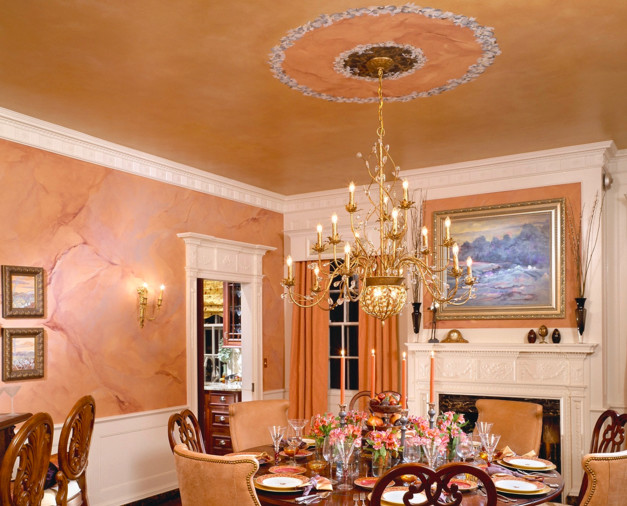 Inspiration för mellanstora klassiska separata matplatser, med en standard öppen spis, en spiselkrans i trä och orange väggar