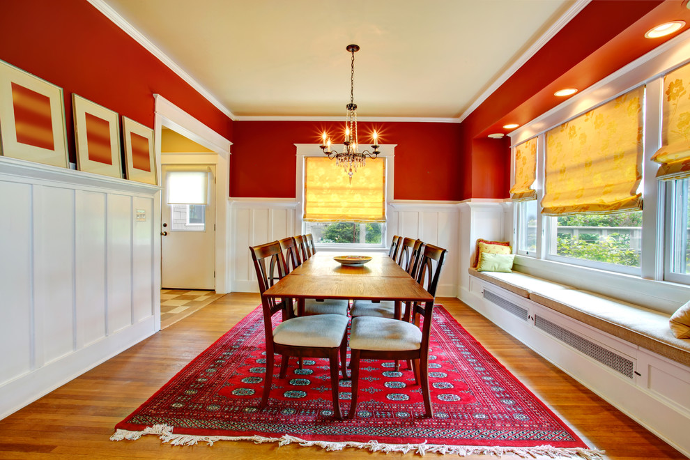 Esempio di una grande sala da pranzo aperta verso il soggiorno tradizionale con pareti rosse, nessun camino, pavimento in legno massello medio e pavimento marrone