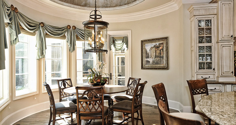 Immagine di una sala da pranzo aperta verso la cucina tradizionale di medie dimensioni con pareti beige, pavimento in compensato e nessun camino