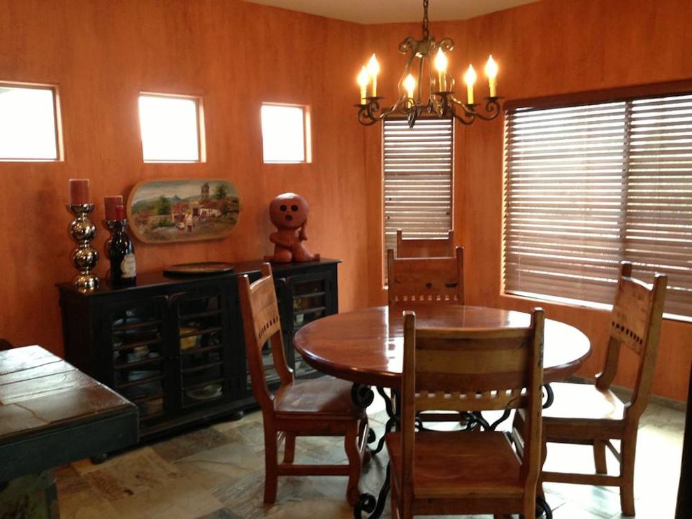 Immagine di una piccola sala da pranzo aperta verso la cucina stile americano con pareti arancioni e pavimento in ardesia