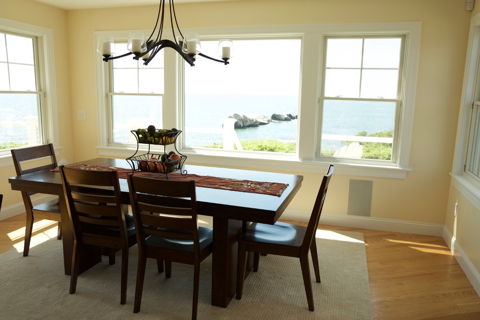 Immagine di una sala da pranzo costiera di medie dimensioni e chiusa con pareti beige, nessun camino e parquet chiaro