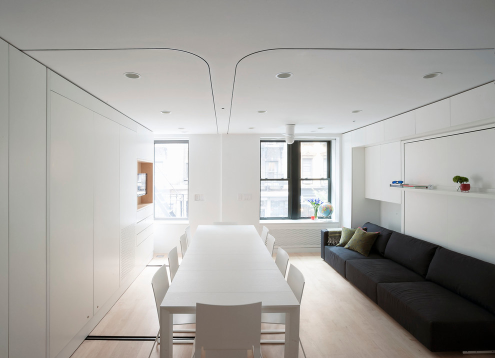 Immagine di una piccola sala da pranzo aperta verso il soggiorno moderna con pareti bianche e nessun camino