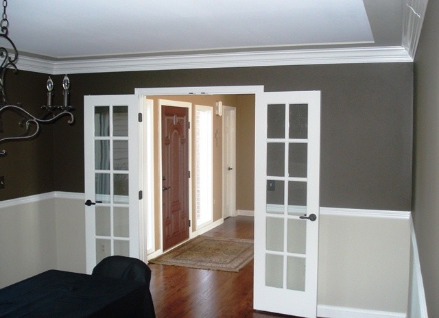 Aménagement d'une salle à manger classique fermée et de taille moyenne avec un mur gris et un sol en bois brun.