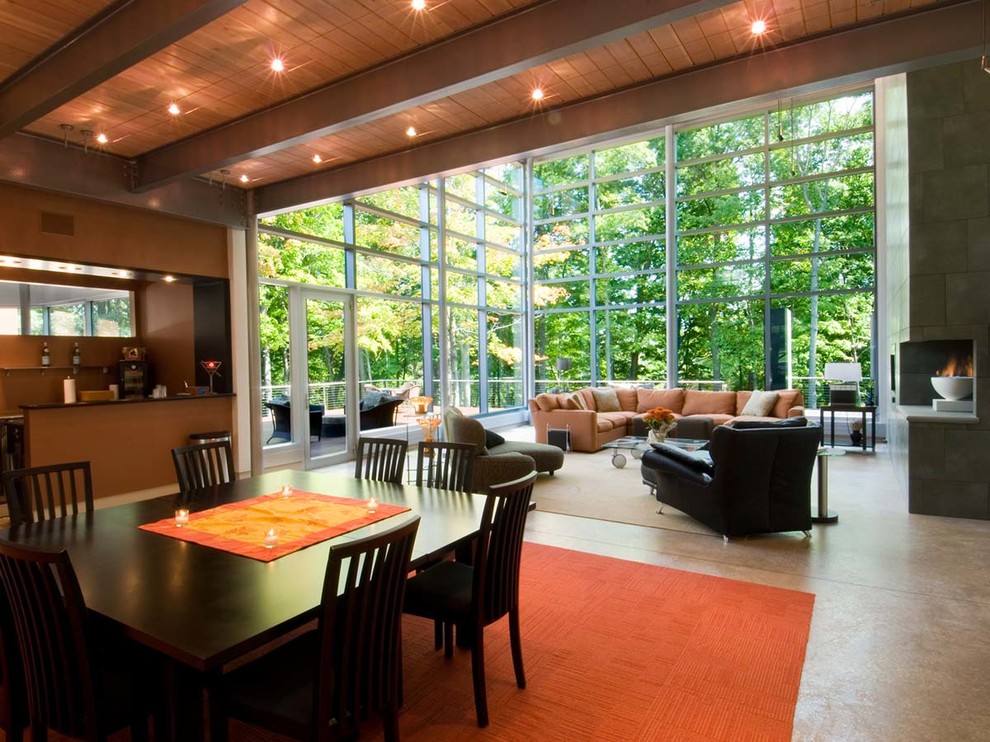 Immagine di un'ampia sala da pranzo aperta verso il soggiorno minimal con pareti bianche e pavimento in cemento