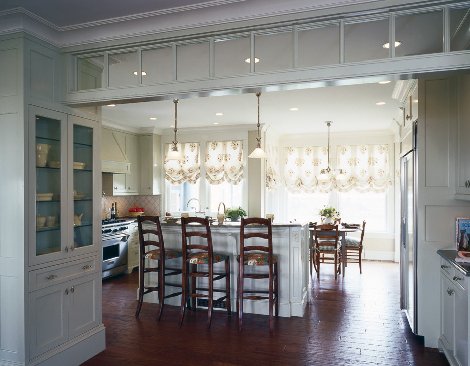 Esempio di una sala da pranzo aperta verso la cucina chic di medie dimensioni con pareti bianche e pavimento in legno massello medio