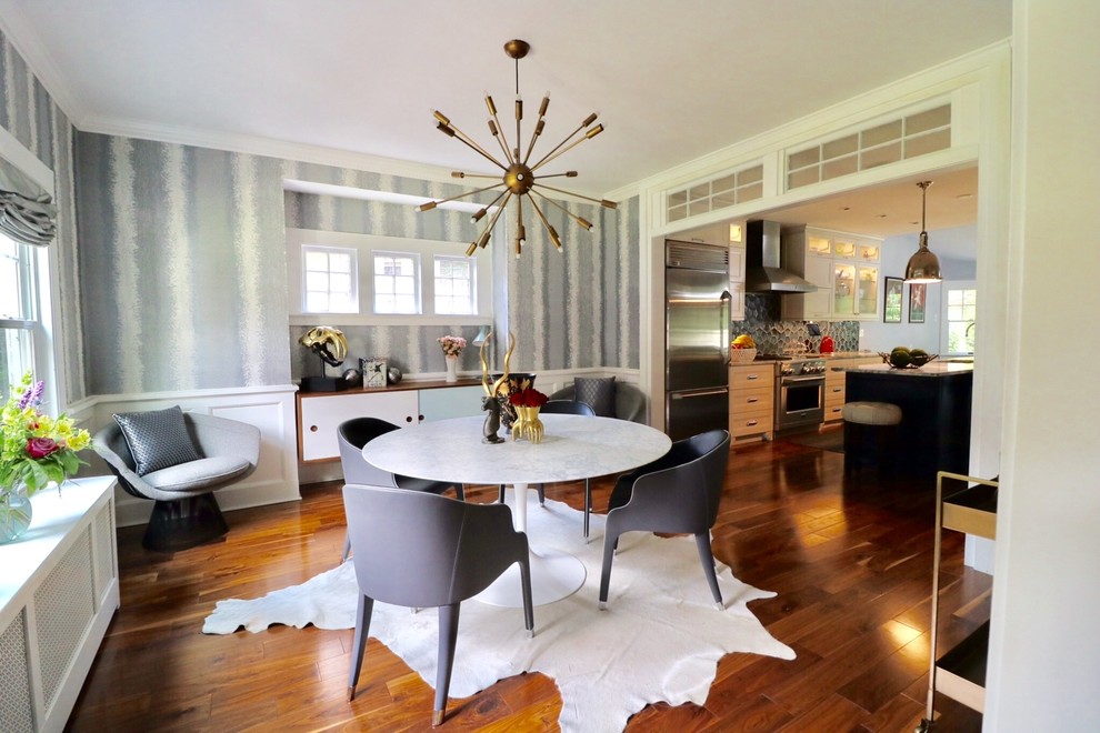 Foto di una grande sala da pranzo aperta verso la cucina minimalista con pareti bianche, pavimento in legno massello medio, nessun camino e pavimento marrone