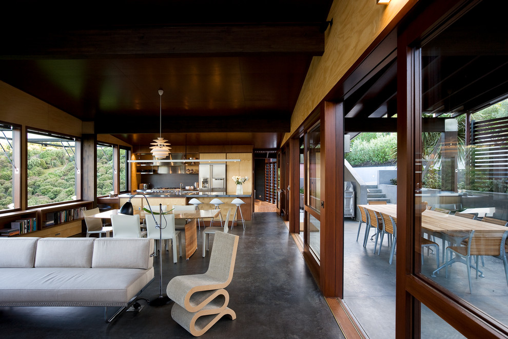 Cette image montre une salle à manger ouverte sur la cuisine design avec sol en béton ciré.
