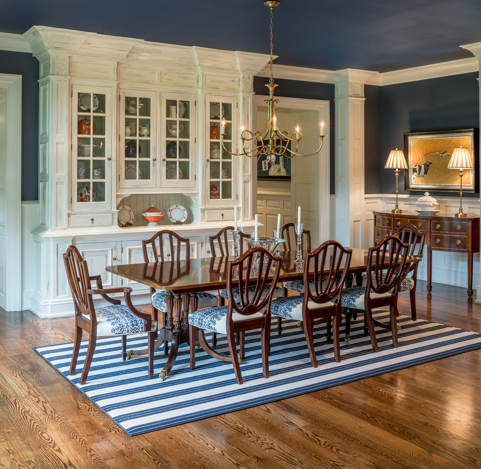 Foto di una grande sala da pranzo tradizionale con pareti blu, pavimento in legno massello medio e pavimento marrone