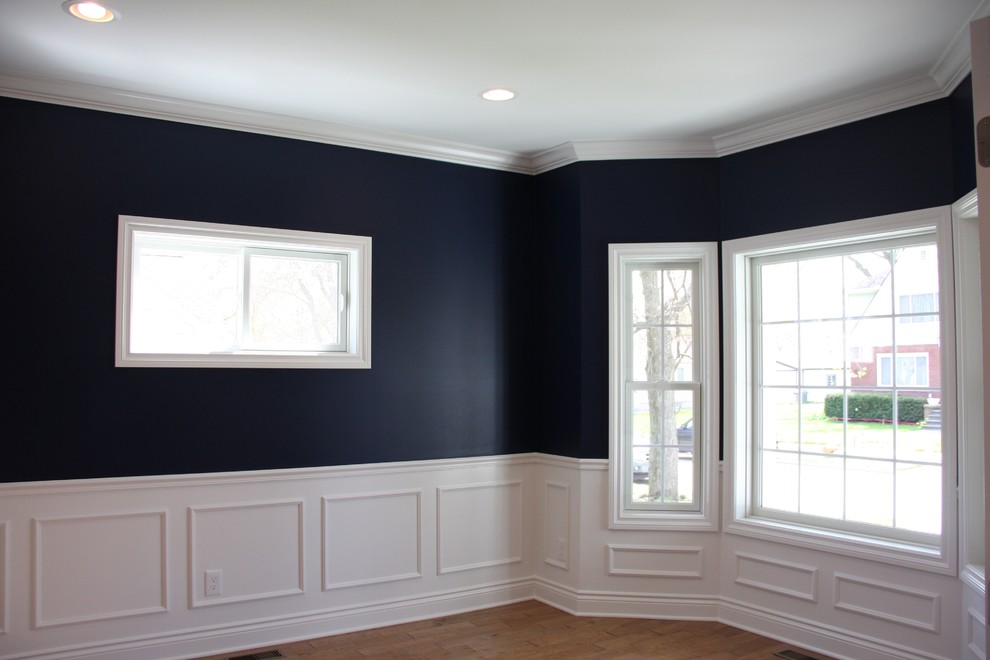 Geschlossenes Esszimmer ohne Kamin mit blauer Wandfarbe, braunem Holzboden und braunem Boden in Detroit