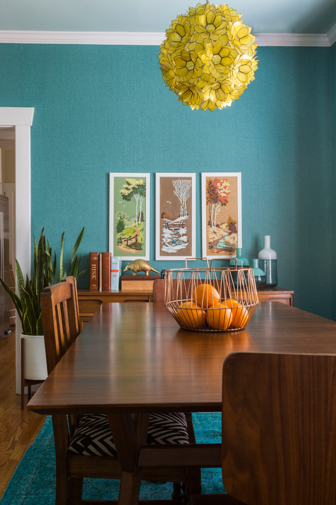 Cette photo montre une petite salle à manger ouverte sur le salon éclectique avec un mur bleu, un sol en bois brun et aucune cheminée.