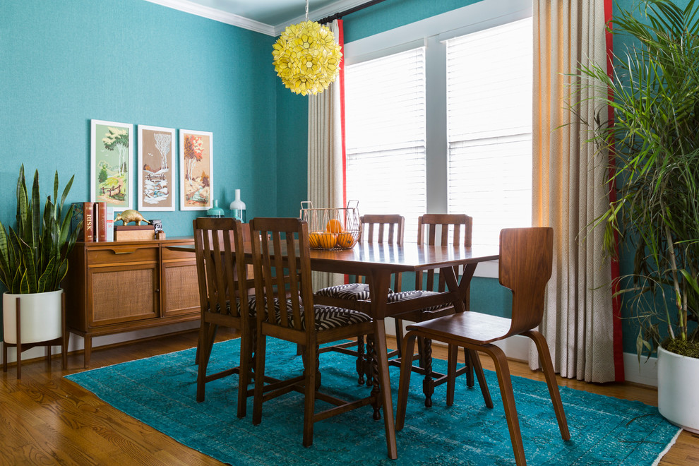 Ispirazione per una piccola sala da pranzo aperta verso il soggiorno boho chic con pareti blu, pavimento in legno massello medio e nessun camino