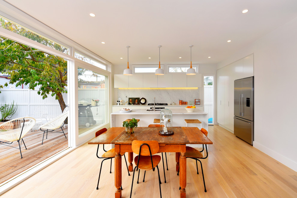 Idee per una sala da pranzo aperta verso la cucina contemporanea di medie dimensioni con pareti bianche, parquet chiaro e nessun camino