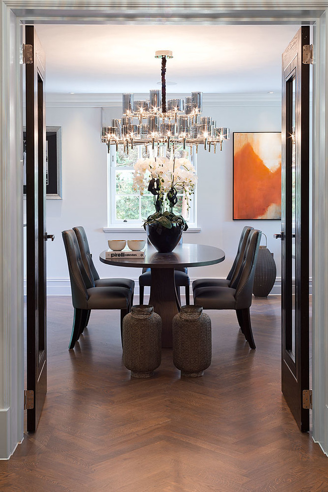 This is an example of a contemporary enclosed dining room in Surrey with white walls and medium hardwood flooring.