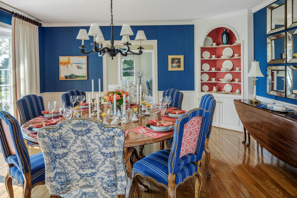 Esempio di una sala da pranzo chic chiusa e di medie dimensioni con pareti blu, pavimento in legno massello medio, pavimento marrone e nessun camino
