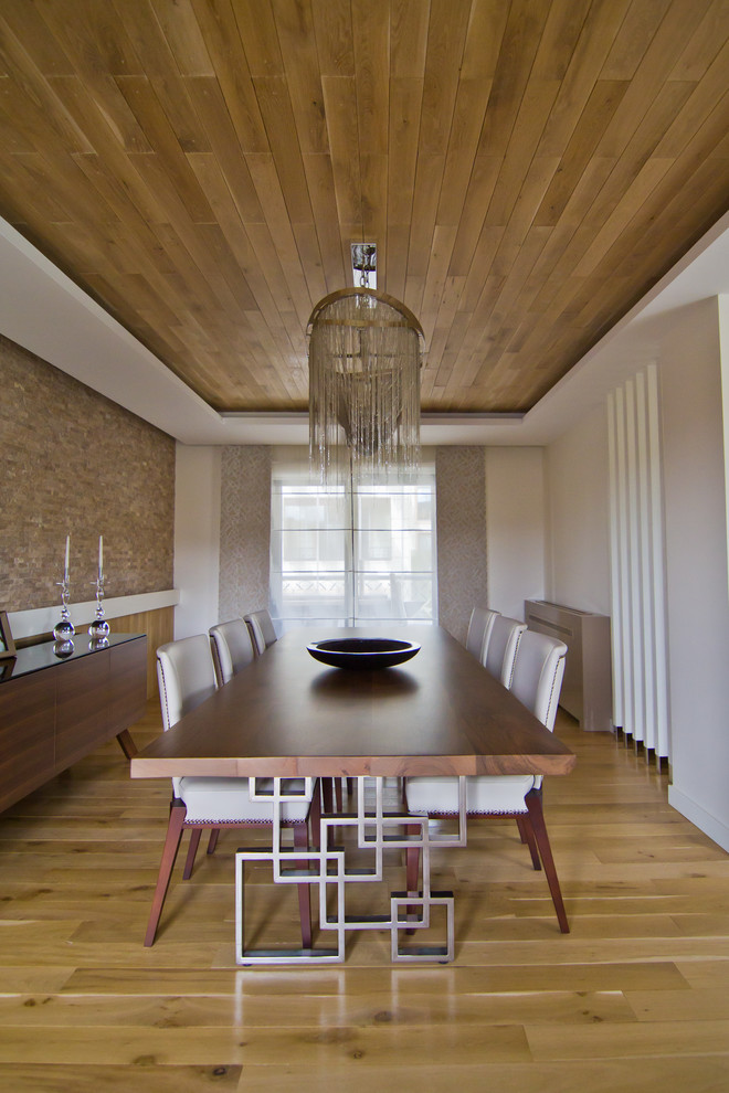 Diseño de comedor contemporáneo con paredes blancas y suelo de madera en tonos medios