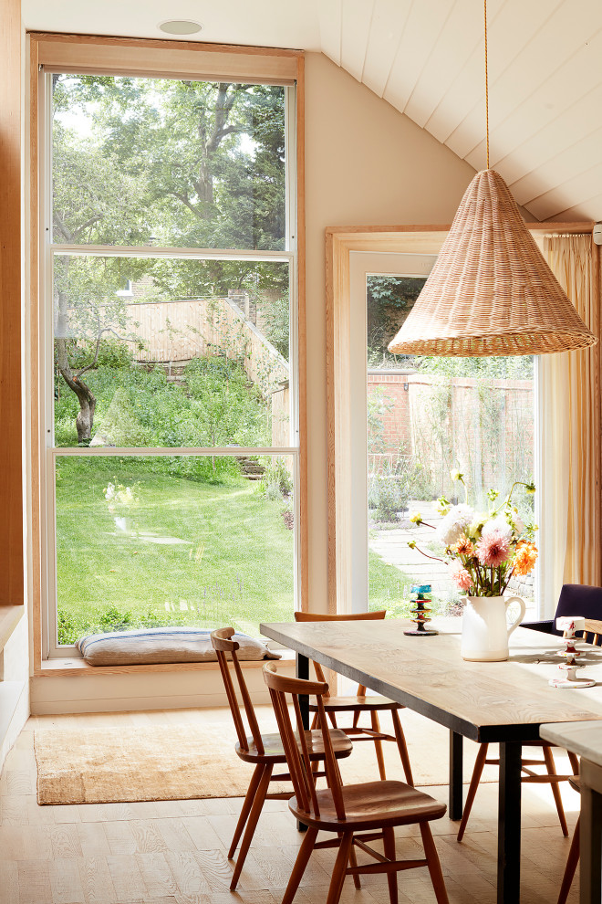 Immagine di una sala da pranzo minimal di medie dimensioni con pareti beige, parquet chiaro e pavimento beige