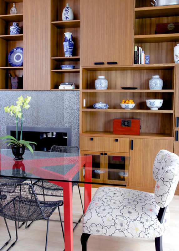 Immagine di una sala da pranzo aperta verso la cucina design con parquet chiaro e camino classico