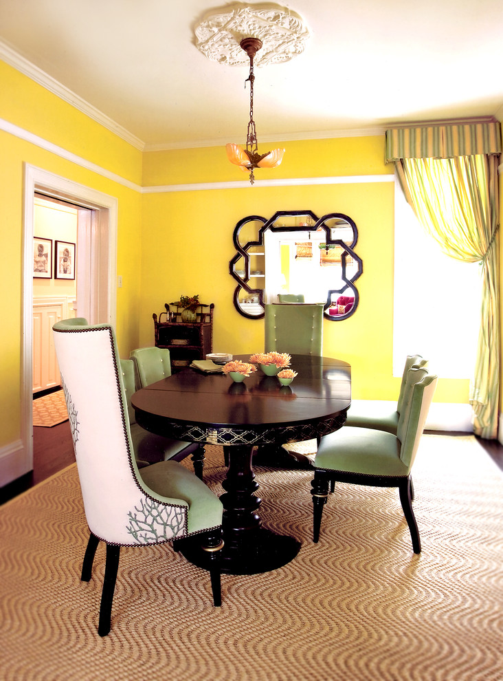 Aménagement d'une salle à manger éclectique avec un mur jaune.