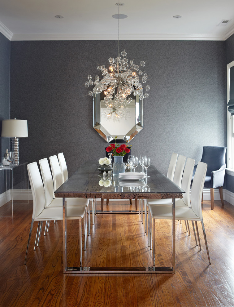 Cette photo montre une salle à manger tendance avec un mur gris, un sol en bois brun et éclairage.