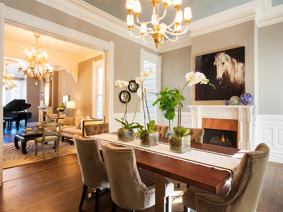 Photo of a classic open plan dining room in San Francisco with beige walls, dark hardwood flooring, a standard fireplace and a stone fireplace surround.