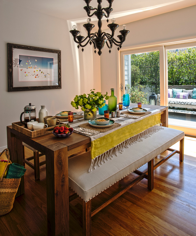 Immagine di una sala da pranzo aperta verso la cucina stile rurale di medie dimensioni con nessun camino, pareti bianche e parquet chiaro