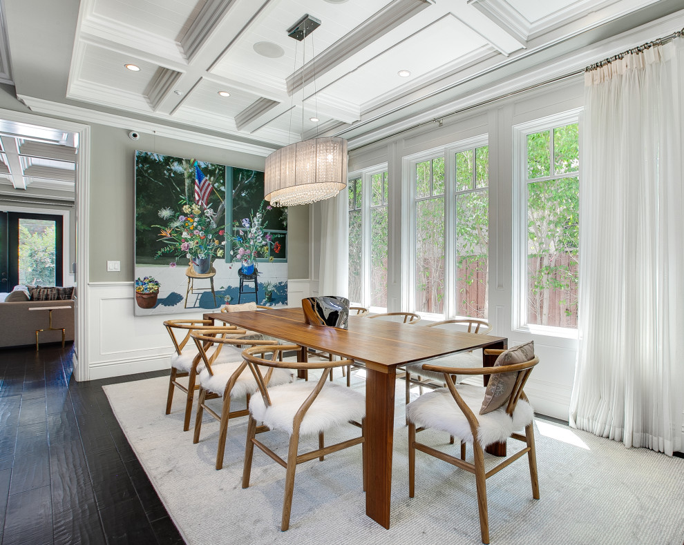 Example of a beach style dark wood floor, black floor, coffered ceiling and wainscoting dining room design in Los Angeles with gray walls