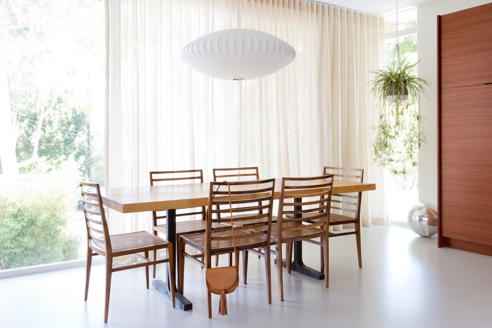 Idée de décoration pour une salle à manger vintage avec un mur blanc et un sol blanc.