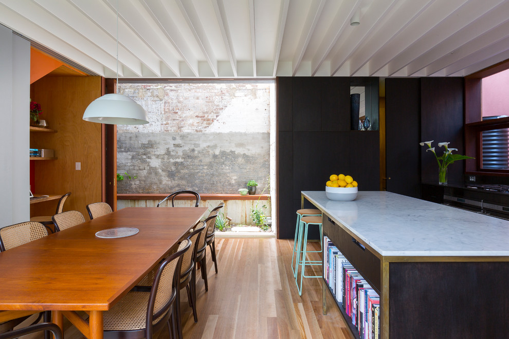 Medium sized contemporary kitchen/dining room in Sydney with multi-coloured walls and medium hardwood flooring.