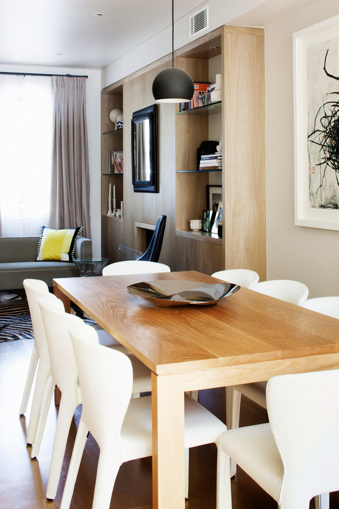Immagine di una piccola sala da pranzo aperta verso il soggiorno minimal con pareti grigie e parquet chiaro