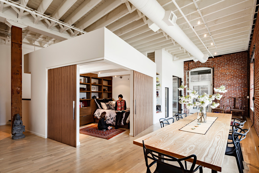 Inspiration for an urban dining room in Portland with light hardwood flooring.