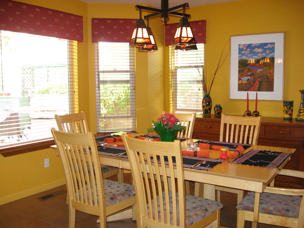 Cette photo montre une salle à manger éclectique de taille moyenne avec un mur jaune, un sol en carrelage de céramique et un sol marron.