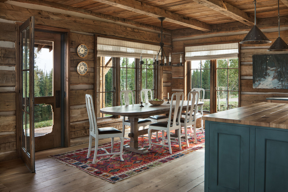 Foto di una sala da pranzo aperta verso la cucina stile rurale con pareti marroni, parquet chiaro e pavimento beige