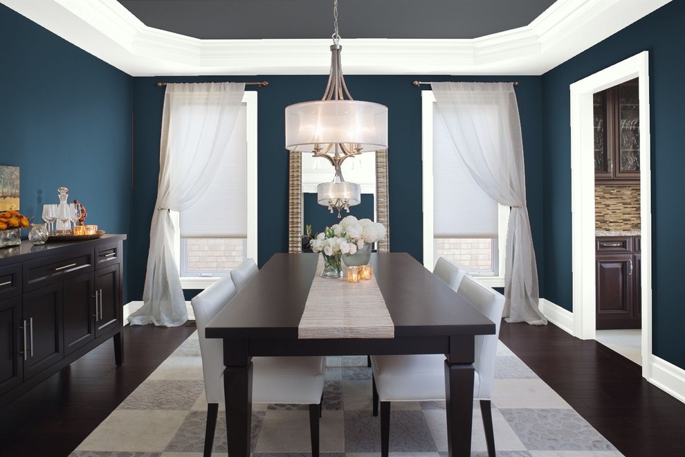 На фото: большая отдельная столовая в стиле неоклассика (современная классика) с синими стенами, темным паркетным полом и коричневым полом без камина