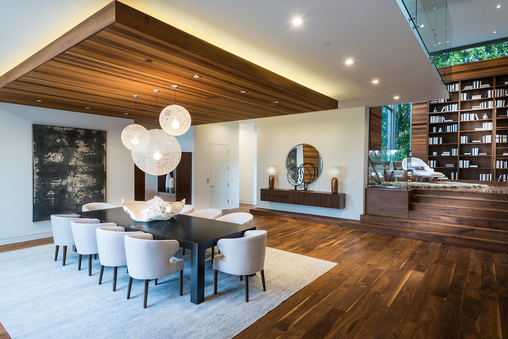 This is an example of a contemporary dining room in Los Angeles with white walls, dark hardwood flooring and brown floors.