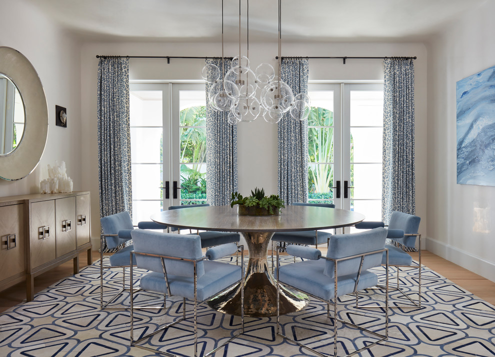 Inspiration for a coastal dining room in Miami with white walls, light hardwood flooring and no fireplace.