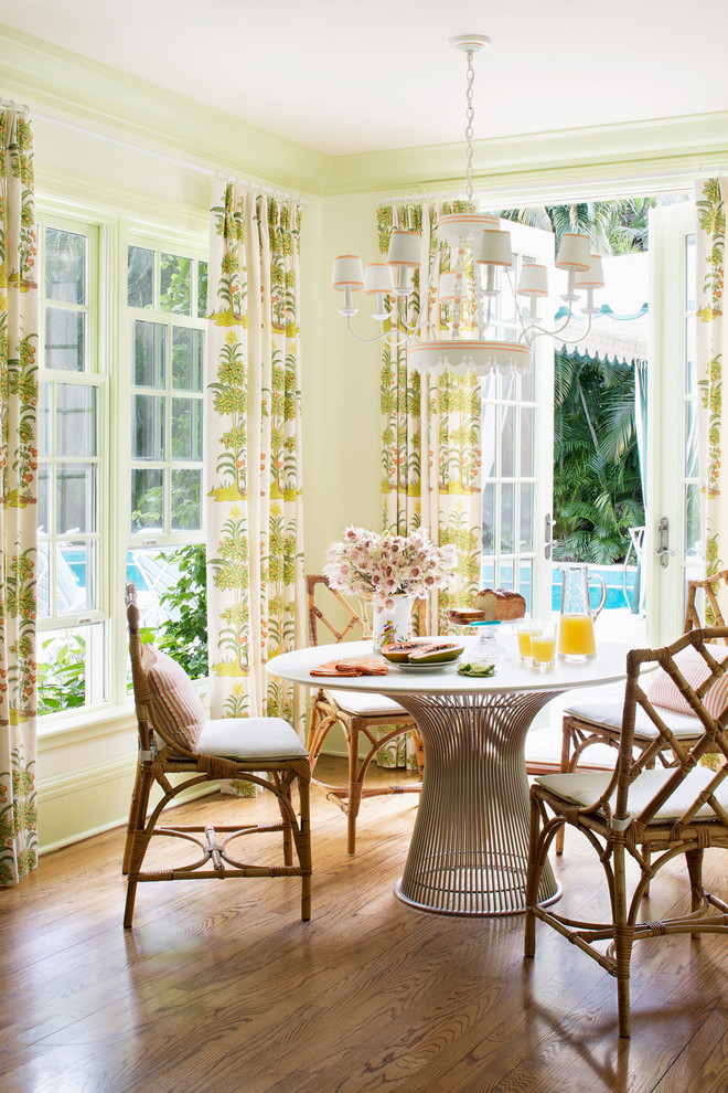 Immagine di una sala da pranzo tropicale con pareti verdi e pavimento in legno massello medio