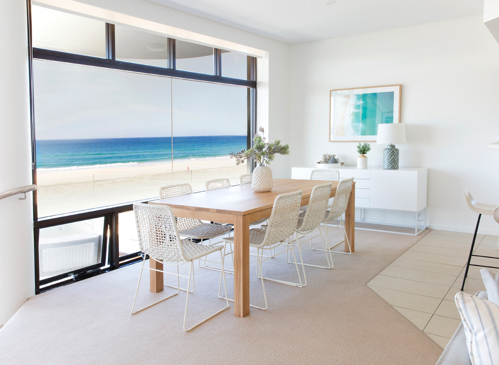 Foto di una sala da pranzo aperta verso il soggiorno stile marinaro di medie dimensioni con pareti bianche, moquette e pavimento beige