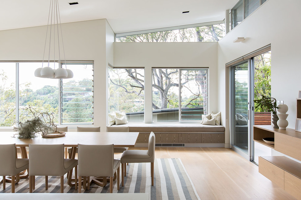 Coastal dining room in Sydney with white walls and light hardwood flooring.
