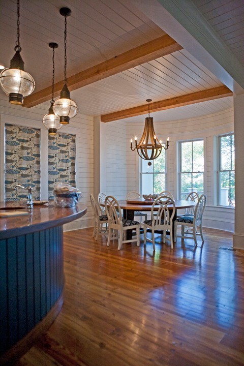 Idées déco pour une salle à manger ouverte sur la cuisine exotique de taille moyenne avec un mur blanc, un sol en bois brun et aucune cheminée.