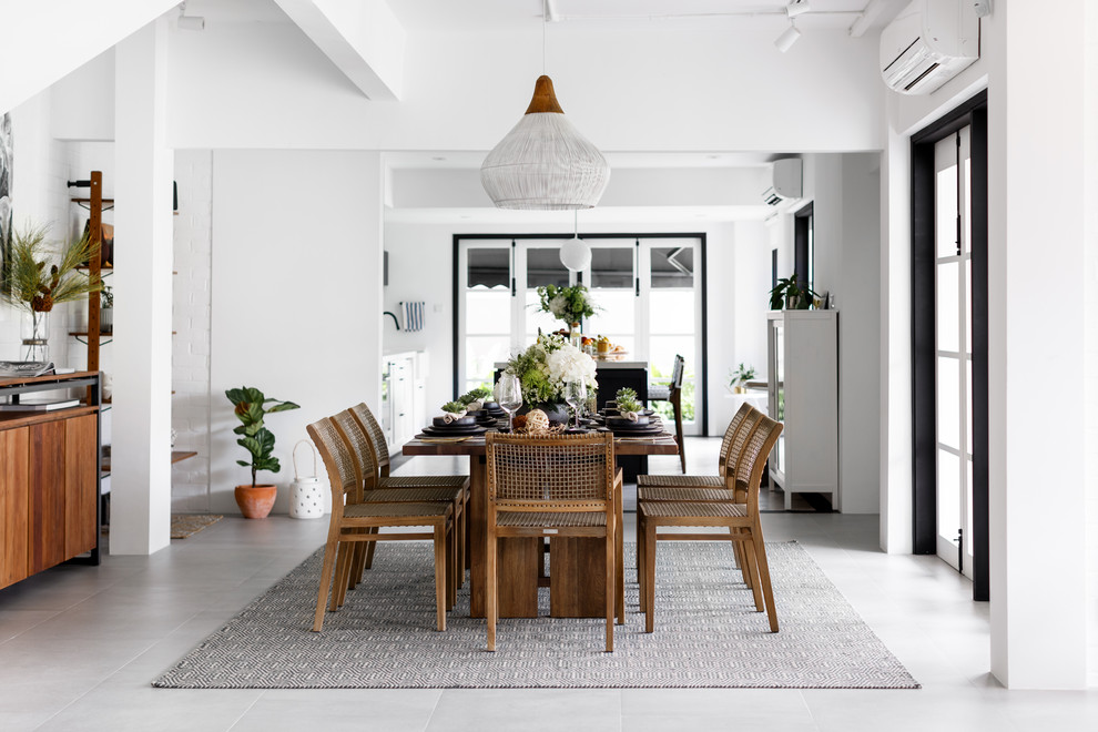 This is an example of a contemporary dining room in Singapore with white walls and grey floors.