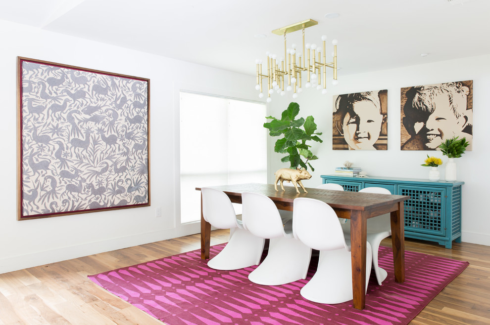 Ispirazione per una sala da pranzo aperta verso il soggiorno bohémian di medie dimensioni con pareti bianche e pavimento in legno massello medio