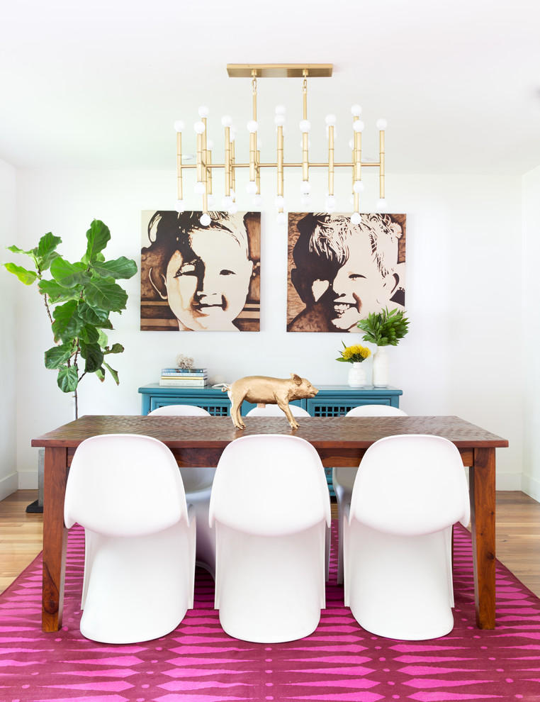 Inspiration pour une salle à manger ouverte sur le salon design de taille moyenne avec un mur blanc et un sol en bois brun.