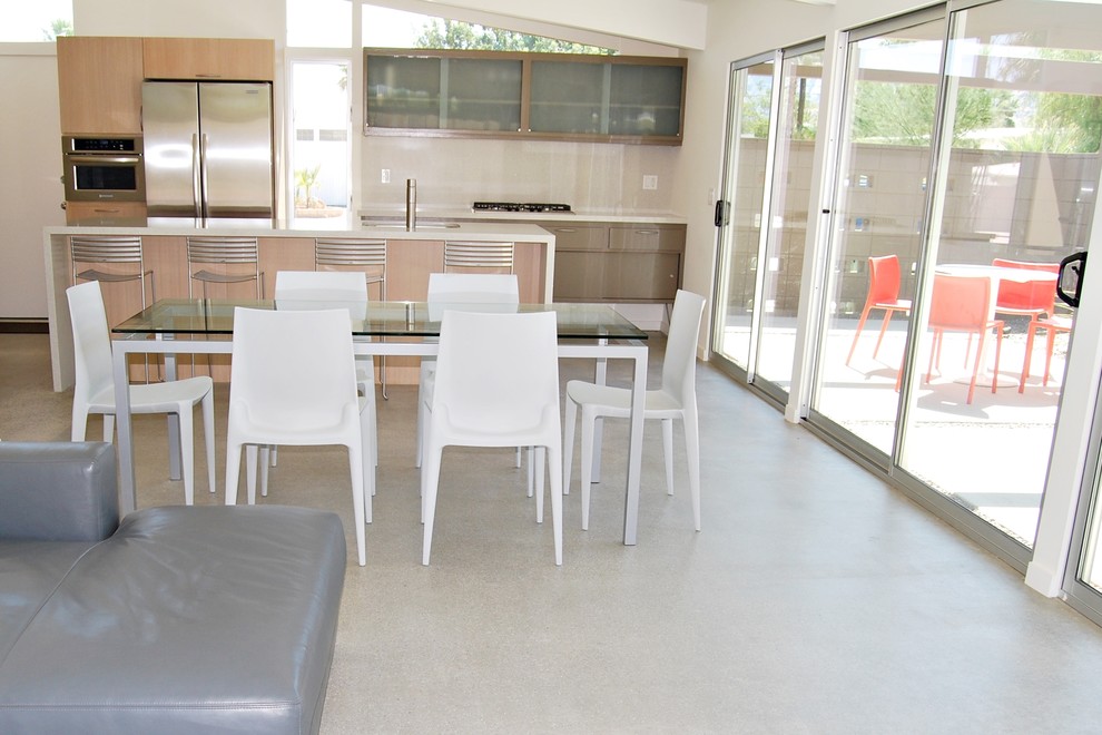 Immagine di una sala da pranzo aperta verso la cucina minimalista di medie dimensioni con pareti beige e pavimento in cemento