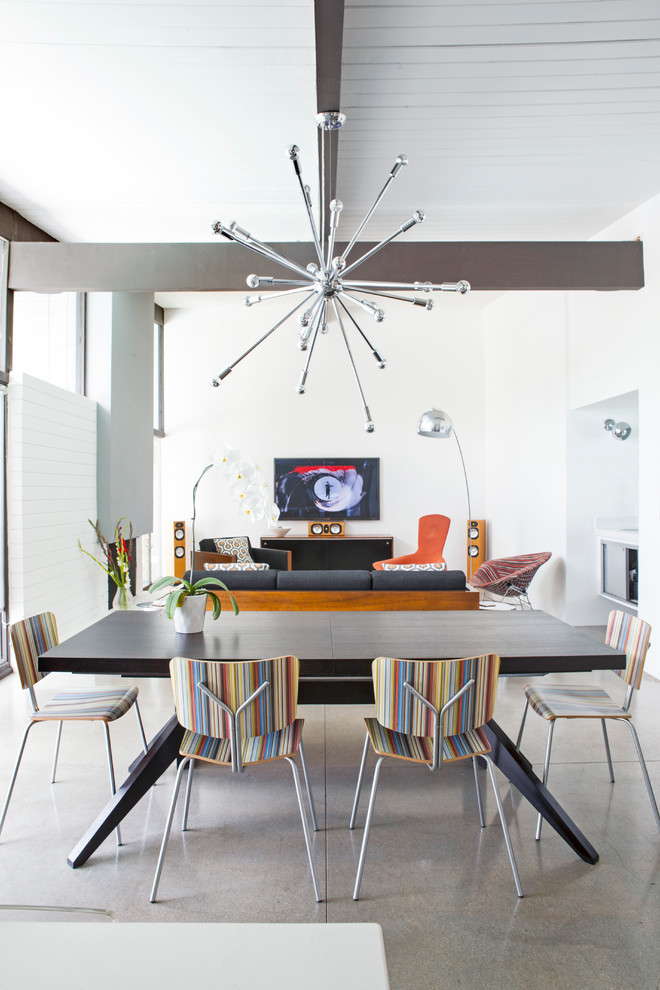 Esempio di una sala da pranzo aperta verso il soggiorno minimalista con pareti bianche, pavimento in cemento e pavimento grigio