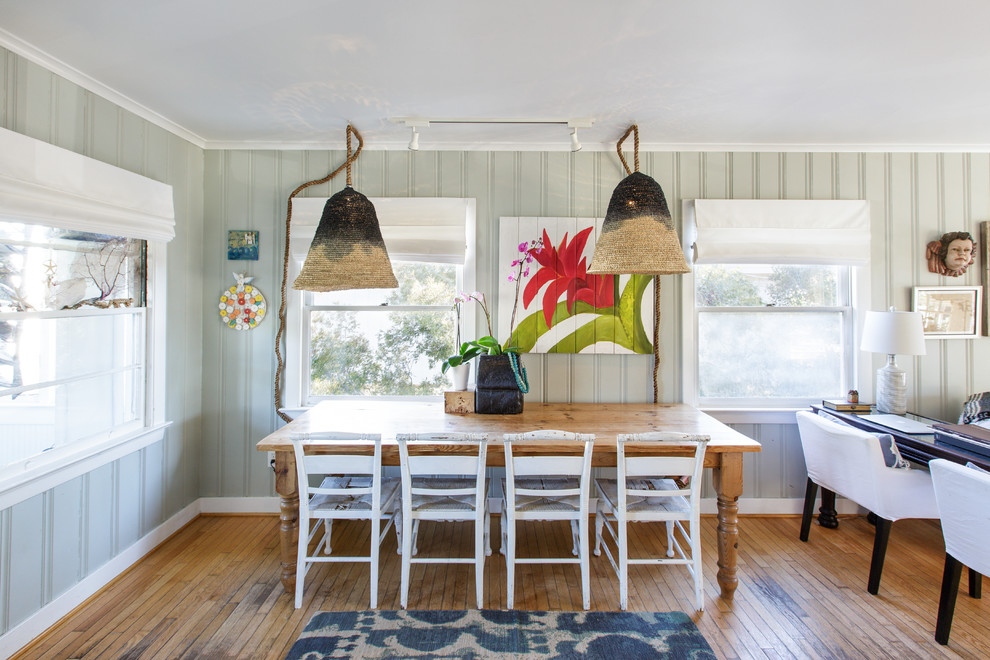 Coastal dining room in Other with green walls, medium hardwood flooring and brown floors.