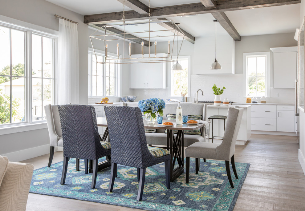 Immagine di una sala da pranzo aperta verso il soggiorno stile marinaro con pareti grigie, parquet chiaro e pavimento beige