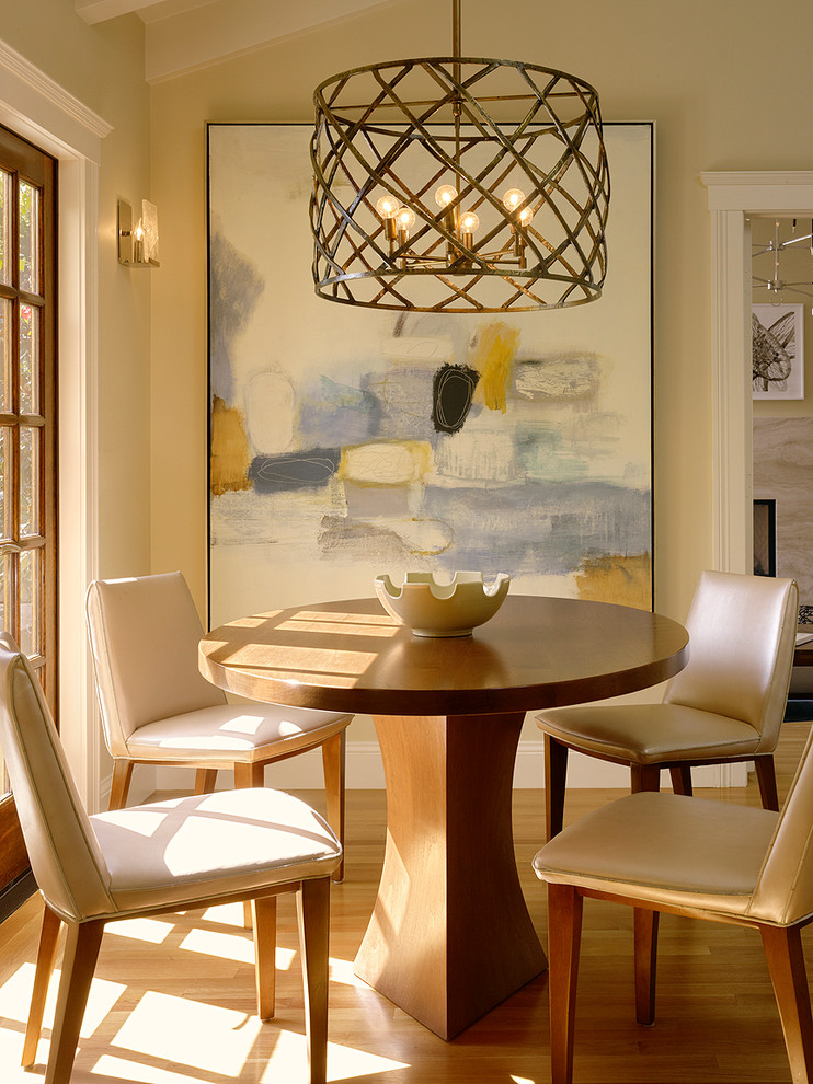 Cette photo montre une salle à manger ouverte sur la cuisine chic de taille moyenne avec un mur beige, un sol en bois brun, aucune cheminée et un sol marron.